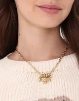 Collar corto dorado con cadena de eslabones grandes y dijes colgantes de flores y piedras rojas.