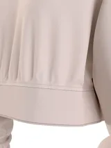 Buzo Calvin Klein Jeans color beige, de corte cropped, con cuello en V y logo bordado en el pecho.
