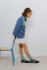 Buzo de algodón con cierre metálico y bordados de flores. Diseño color block en verde y azul.