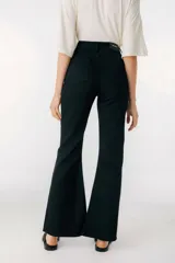 Pantalón de jean azul de corte acampanado con aberturas en el ruedo.