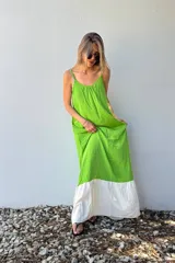 Vestido largo verde con corte recto y falda blanca.