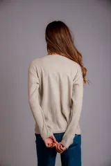 Blusa de morley elastizado color beige, de calce ajustado y mangas largas.