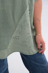 Blusa verde militar de lino, corte holgado, mangas cortas, cuello redondo y bolsillo en el pecho.