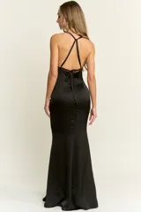 Vestido largo de fiesta negro, corte sirena, con escote profundo en V y espalda descubierta. Confeccionado en tela fluida.