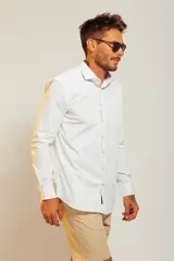 Camisa blanca de vestir con finas rayas verticales celestes, de corte clásico y manga larga.