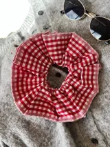Goma de pelo con estampado a cuadros rojos y blancos.