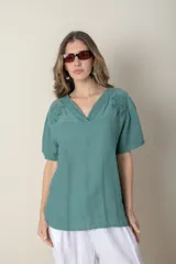 Blusa italiana de lino color verde agua, con escote en V, mangas cortas y detalle de bordado calado en el canesú.