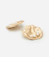 Caravanas de metal con acabado martillado en color dorado, de tamaño mediano y forma irregular orgánica. Cuentan con aplicaciones de perlas artificiales blancas en su superficie.