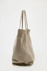 Bolso tipo maxi shopper color beige de ante, con doble asa de hombro y bolsillo interior con cremallera.