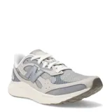 Championes New Balance Arishi V4, color gris claro con detalles en gris oscuro y blanco. Capellada de malla transpirable con sobrecapas sin costuras, mediasuela Fresh Foam y suela de goma resistente.