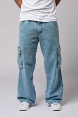 Pantalón jean celeste de corte amplio, estilo cargo, con bolsillos laterales con fuelle y solapa.
