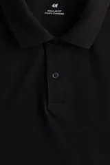 Remera polo negra de piqué de algodón, manga corta, cuello clásico con tapeta de botones y corte estándar.