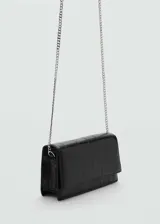 Bolso de mano negro con efecto piel y textura de cocodrilo. Tiene diseño rectangular, tamaño pequeño, bandolera y cierre de solapa con botón magnético.