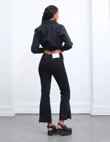 Pantalón de jean azul oscuro con corte acampanado y tajo en los laterales.