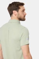 Camisa celeste de piqué con manga corta, botones personalizados y logo bordado a tono.