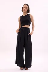 Pantalón negro de corte palazzo, con cintura elástica y bolsillos laterales.