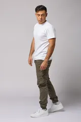 Pantalón cargo color beige de gabardina, con corte ajustado, bolsillos laterales con fuelle y puños elásticos en los tobillos.
