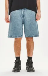 Bermuda de denim celeste con calce oversize, estilo carpintero y proceso de efecto desgaste.