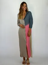 Vestido largo tipo camisero con diseño color block en tonos gris, azul y rosa. Tiene cuello camisero, mangas largas con puños abotonados, cierre frontal con botones y tajo lateral.