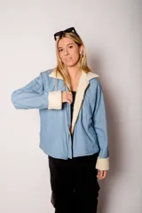 Chaqueta de mezclilla azul con interior de corderito blanco y cierre frontal.
