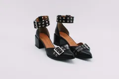 Zapato plateado de cuero con taco cuadrado, punta fina y pulsera con hebilla y ojales.