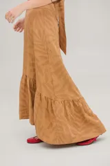 Vestido largo color ocre con estampado de hojas, escote halter cruzado y falda acampanada con volantes.