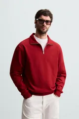 Sudadera color crema de corte recto, con cuello polo y cierre de cremallera metálica.