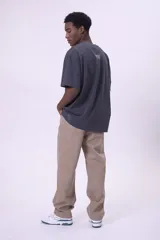 Camiseta de manga corta, color gris oscuro con efecto lavado, corte oversize y cuello redondo. Presenta texto estampado en blanco en el pecho que dice "CREW MEMBER".