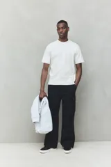 Remera de hombre color gris claro jaspeado, de corte holgado, cuello redondo y manga corta. Confeccionada en tejido de punto de algodón pesado.