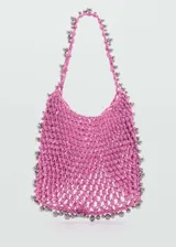 Bolso shopper grande color fucsia, con diseño trenzado y abalorios plateados irregulares. Tiene asa de hombro y no posee cierre.