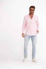 Camisa de hombre color crema, de corte clásico, con cuello abotonado y mangas largas.