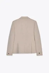 Blazer color beige de corte entallado, con cuello solapa y mangas largas. Tiene bolsillos con solapa en la parte delantera y cierre cruzado con botones.