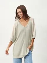 Remera color beige con escote en V y mangas cortas ranglán en color crema.