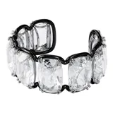 Brazalete con cristales transparentes grandes en montura negra, creando un efecto óptico de piedras flotantes.