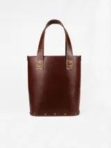 Matera de cuero color marrón con bolsillo exterior con textura de piel de cocodrilo. Interior forrado con compartimento para el mate y bolsillo de cuero.