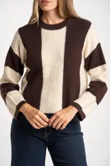 Sweater de tejido grueso con diseño de bloques verticales en marrón oscuro y beige claro. Presenta cuello redondo y mangas largas.
