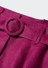 Short de lino color fucsia, de tiro alto, con pinzas delanteras, bolsillos laterales y cinturón con hebilla redonda.