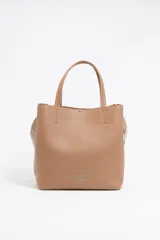 Bolso tote negro de cuero vacuno con doble asa corta y correa de tela extraíble. Interior con tres compartimentos y bolsillo con cremallera. Logo metálico de la marca en el frente.