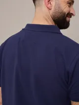 Chomba negra de piqué de algodón, corte clásico, con cuello y mangas acanalados y tapeta con dos botones blancos. Logo bordado en el pecho.