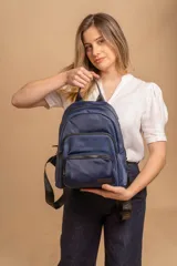 Mochila funcional color beige con detalles en negro, que incluye dos compartimentos con cierre y un bolsillo frontal para fácil acceso.