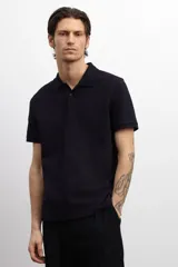 Remera polo negra de piqué de algodón, de corte estándar, con cuello clásico, tapeta de botones, mangas cortas y remate acanalado en cuello y mangas.