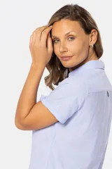 Camisa de lino color salmón, de corte clásico, con cuello camisero, medio abotonada, de manga corta y con dos bolsillos frontales con solapa.