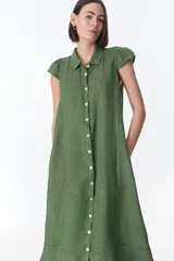 Vestido camisero celeste de lino, corte midi, con cuello camisero, mangas cortas con volados y abotonadura frontal.
