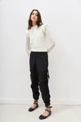 Pantalón jogger negro de nylon con elástico ancho en la cintura, puños elásticos ajustables y lazos laterales para fruncir.