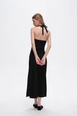 Vestido midi negro de poliéster, con breteles finos, escote halter y corte ajustado al cuerpo.