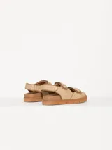Sandalias bajas color beige con tiras de rafia y ajuste con velcro.