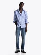 Camisa de mangas largas Tommy Hilfiger de corte regular, confeccionada en popelín de algodón a rayas verticales celestes y blancas.