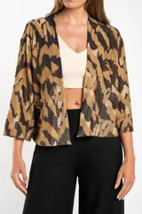 Kimono con estampado abstracto en tonos marrón, beige y negro. Tiene mangas 3/4 y bolsillos laterales.