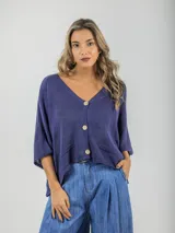 Cárdigan tejido color azul con botones de madera, talle único y calce oversized.