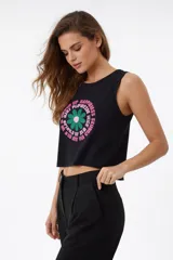 Musculosa de algodón color lila, corte holgado y sin mangas, con cuello redondo a la base. Presenta un estampado frontal de flores estilizadas en amarillo y azul con texto.